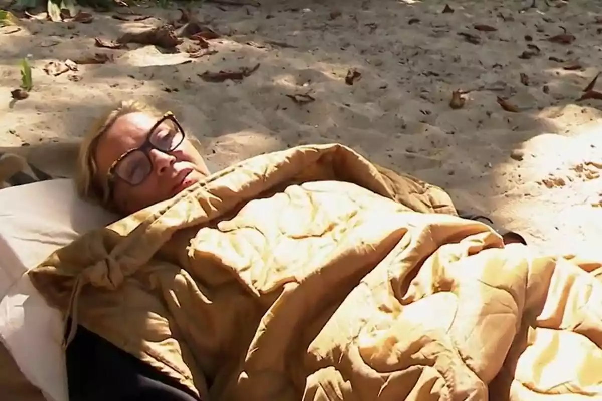 Carmen Borrego tumbada en la playa tapada con una manta en Supervivientes