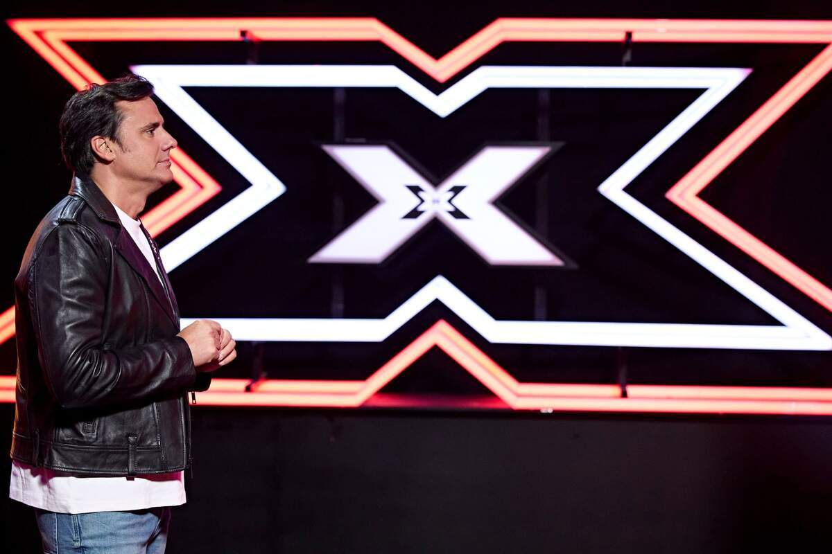Fotografía de Ion Aramendi de perfil delante del logo de Factor X