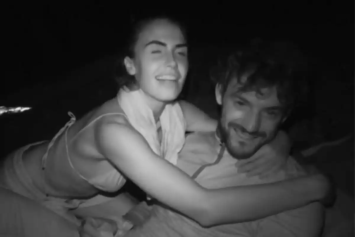Captura de Sofía Suescun y Logan Sampedro en Supervivientes abrazándose y sonriendo en una foto en blanco y negro tomada de noche